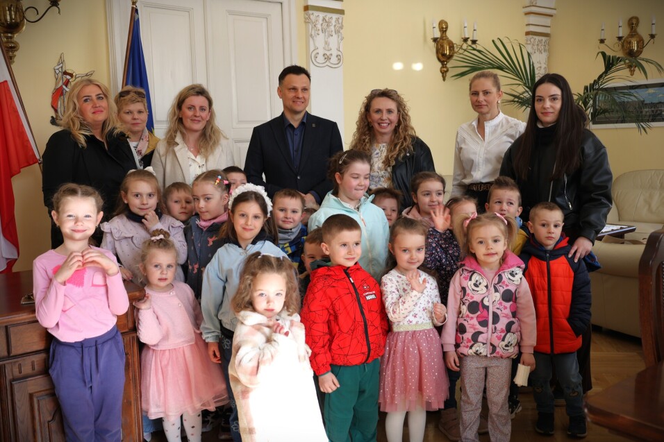 Wizyta świąteczna przedszkolaków z&nbsp;MP 10. Wspólne pamiątkowe zdjęcie z&nbsp;burmistrze miasta, zastępcą burmistrz oraz skarbnik miasta.