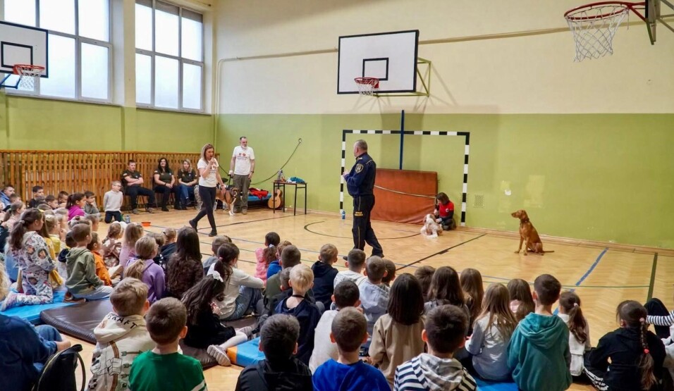 Edukacja z&nbsp;merdającym ogonem - spotkanie w&nbsp;SP 5. Sala gimnastyczna wypełniona dziećmi słuchającymi o zasadach opieki nad czworonogami